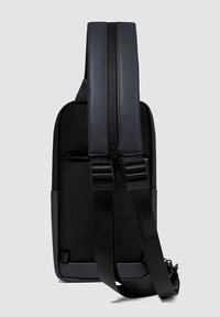 Zaino nero realizzato in tessuto texturizzato e materiale liscio, dotato di una tracolla regolabile e di una doppia cerniera per la chiusura.