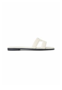 Flat slide sandal with black sole and wide white straps forming an open-toe design, viewed from the side.