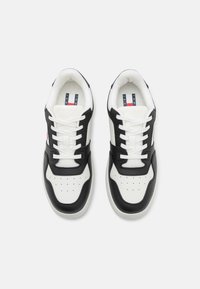 Sneakers bianchi e nere con tomaia in pelle, punta perforata e design con lacci. Presentano una suola testurizzata e una soletta con motivo.