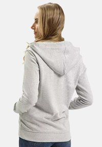 Szara bluza z kapturem o miękkiej fakturze, z regulowanym kapturem, długimi rękawami i luźnym krojem. Widok z tyłu podkreśla prosty design.