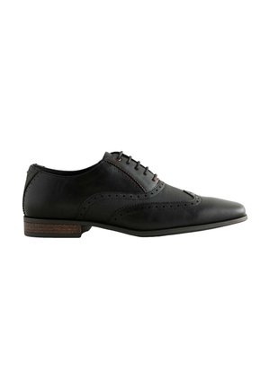 Chaussure habillée en cuir noir avec un bout pointu, des perforations décoratives, des panneaux texturés et un talon en bois. Les lacets et les coutures rouges rehaussent le design.