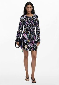 Lilleline must kleit pika varrukaga, kogutud vöökohaga ja lipsudetailiga. Kaasas segu roosadest ja kollastest lilledest, millele on lisatud must käekott.