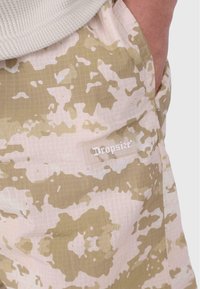 Lette, mønstrede cargo shorts i beige og tan med en gitterstruktur og et "Dropsize" logo mærke på cargo lommen.