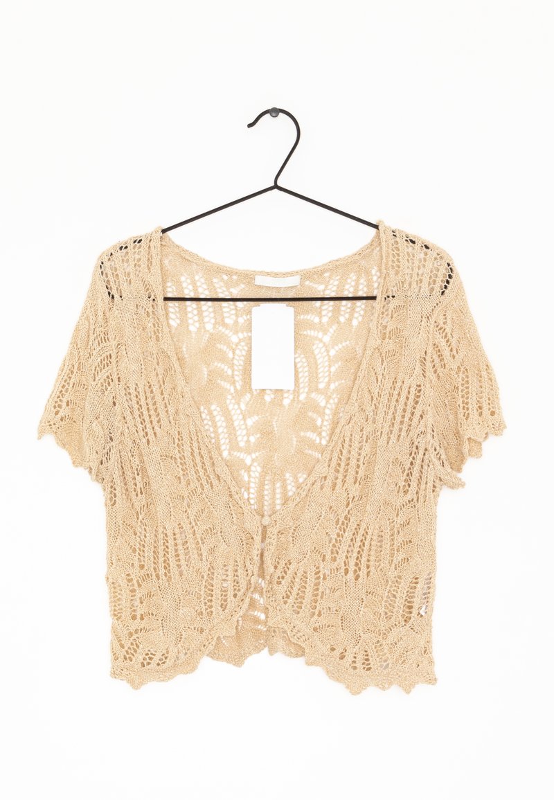 Cárdigan beige de ganchillo con mangas cortas, apertura frontal y detalles intrincados con patrón de hojas. Etiqueta colgante adjunta en el centro de la parte trasera.