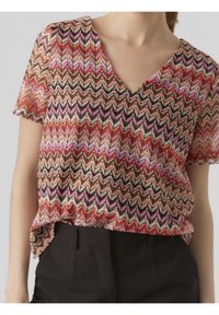 Blouse à manches courtes multicolore avec un motif en zigzag dans les tons de rose, noir et beige, dotée d'un col en V et d'une coupe ample.
