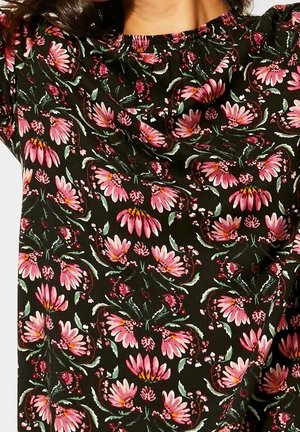 Haut en tissu noir avec un motif floral comprenant des fleurs roses et des feuilles vertes, encolure froncée et design fluide. Texture lisse.