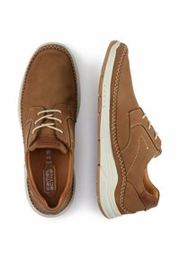 Braune Lederschuhe mit weißer Gummisohle, die über gestickte Akzente, runde Schnürsenkel und ein bequemes Design für die Freizeit verfügen.