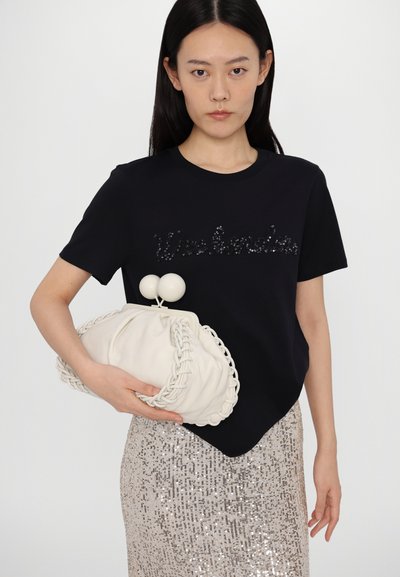 Sort t-shirt med pailletteret "Weekend" skrivning, parret med en hvid clutch med flettet kant og kugleklap, samt en glitrende sølvnederdel.