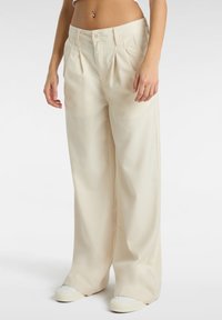 Pantaloni a gamba larga color crema con pieghe, davanti piatto e chiusura con bottone. Realizzati in tessuto morbido, presentano tasche laterali e una vestibilità rilassata.