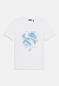 T-shirt en coton blanc avec un graphisme de dragon bleu clair, intégrant des éléments de la lettre 'K' et un éclair, affiché sur le devant.