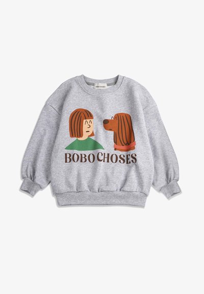 Grauer Kinderpullover mit einer Grafik von einer braunhaarigen Person und einem Hund, die sich einander zuwenden, über dem Text "BOBO CHOSES."