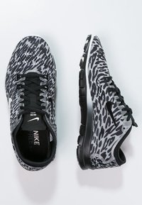 Nike Free sneakers i sort og gråt mønster med fleksibel sål, rund tå, sorte snørebånd og et tekstureret øvre stofdesign.
