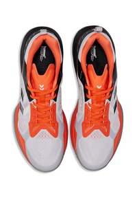 Buty sportowe z białą siateczkową cholewką, pomarańczowymi akcentami, czarnymi detalami i teksturowanymi gumowymi podeszwami; mają jasne sznurowadła i wyściełany kołnierz.