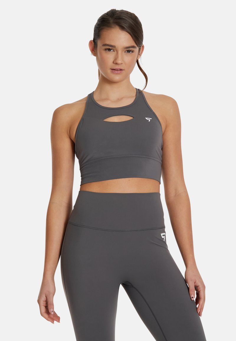 Sivina atletska crop majica s izrezom na prednjem delu, izdelana iz gladkega, elastičnega materiala. Ima obliko racerback in subtilen logotip znamke.