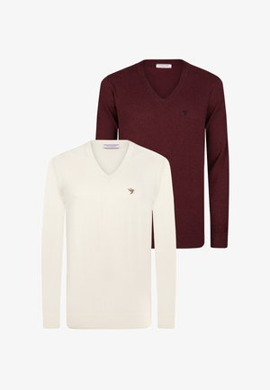 Zwei V-Ausschnitt-Pullover: einer in Weiß, einer in Burgunderrot. Beide haben lange Ärmel und ein kleines Logo auf der linken Brust. Weiches Strickmaterial.