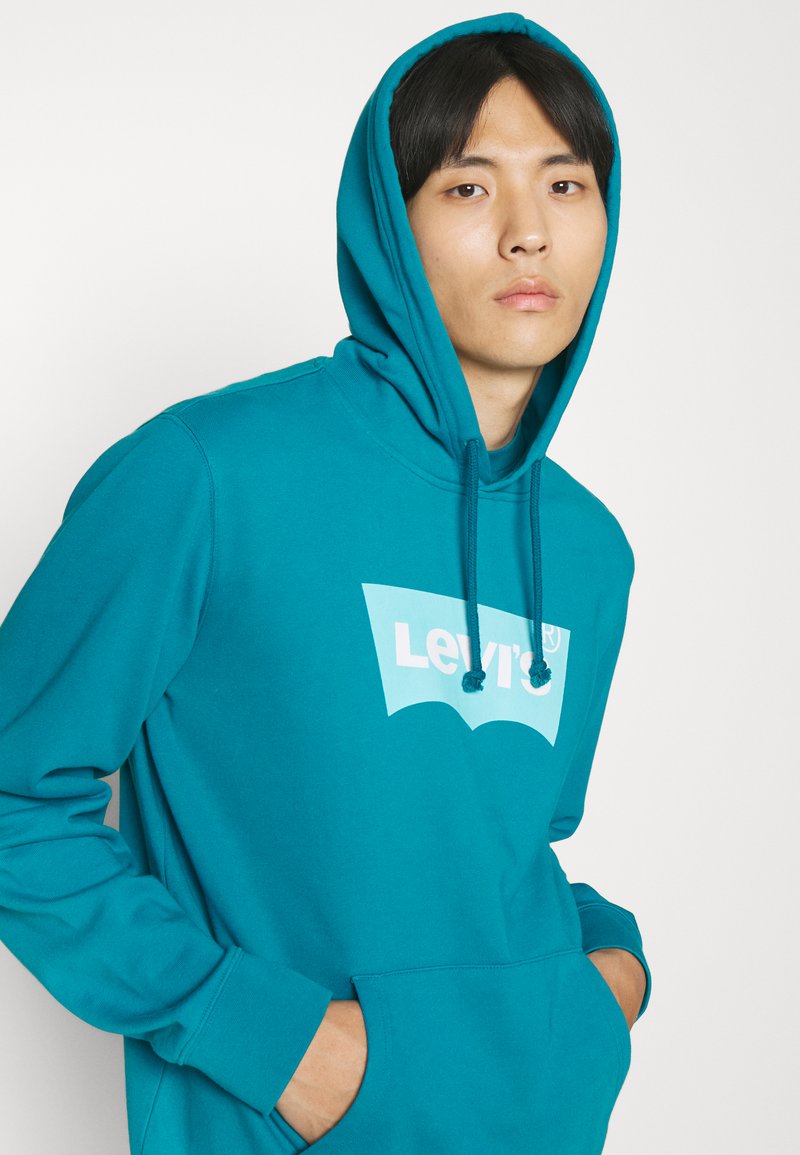 Sudadera turquesa con un bolsillo tipo canguro, cordón ajustable y el logo blanco de Levi's en la parte delantera; confeccionada en tejido suave.