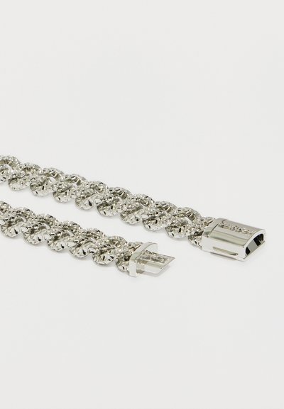 Pulseira de corrente de metal prateado com um design texturizado, apresentando um fecho seguro e extremidades lisas. Os elos são redondos e polidos.