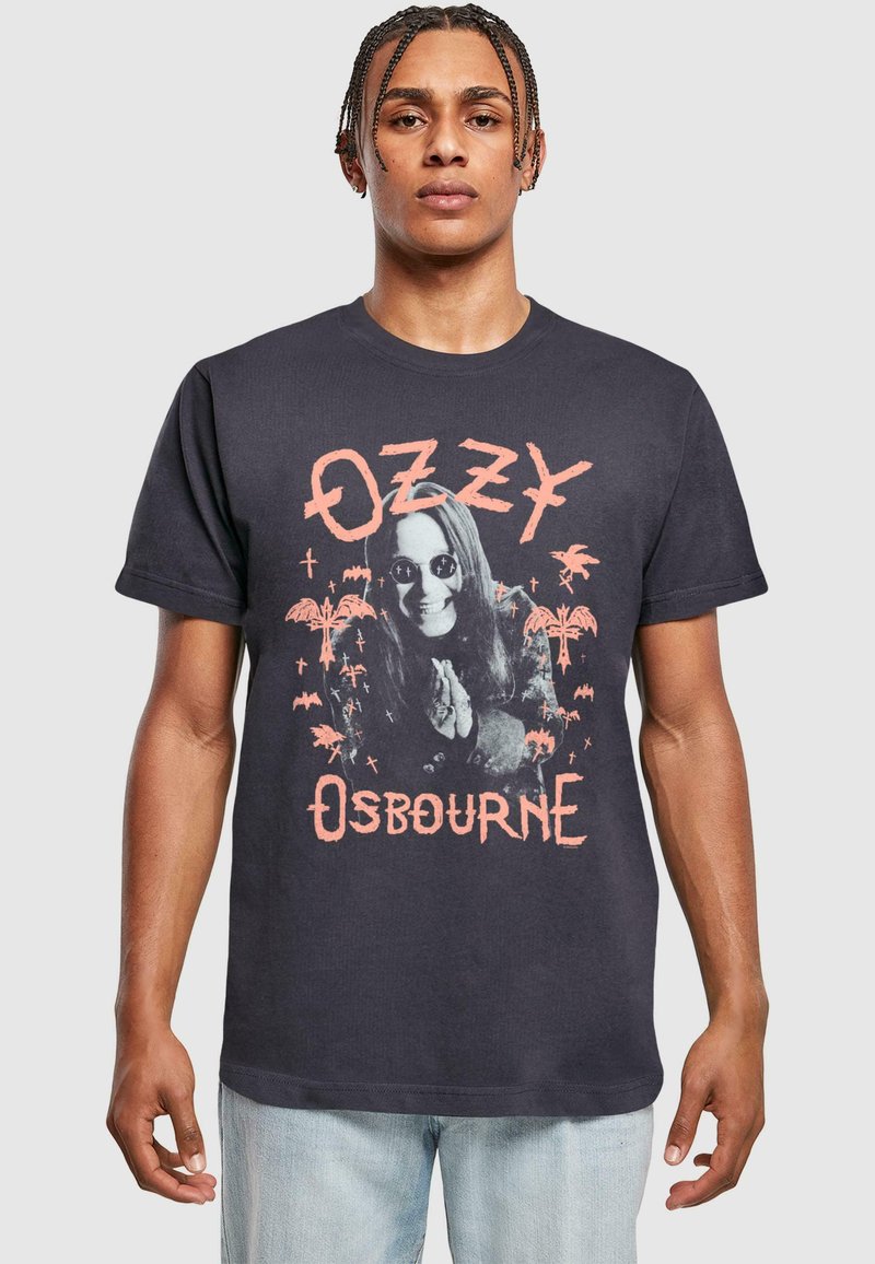 Fekete pamut póló, amelyen egy napszemüveget viselő, hosszú hajú személy grafikájával találkozhatunk, pálmafák és denevérek társaságában, az "OZZY OSBOURNE" felirattal.