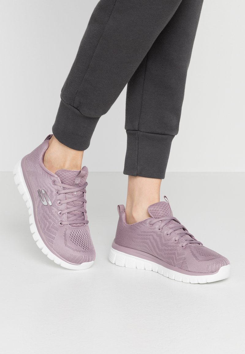 Purpurowe sneakersy sportowe z oddychającą siateczką, z zapięciem na sznurowadła i białą, amortyzującą podeszwą, z teksturą w zygzaki oraz detalem z logo.