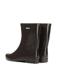 Bottes de pluie noires en caoutchouc avec une finition brillante, dotées d'une semelle plate, d'un bout rond et d'une patch logo sur le côté extérieur. Texture lisse.
