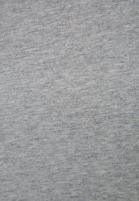 Grå bomullstyg med en slät textur, med ett subtilt, lätt marmorerat mönster över ytan.