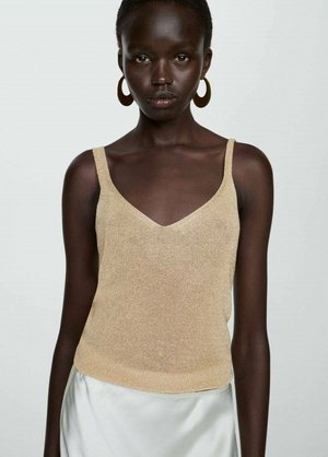 Golden knitted camisole with thin straps, featuring a v-neckline. Smooth texture paired with a flowing silky skirt. Minimalist design.
