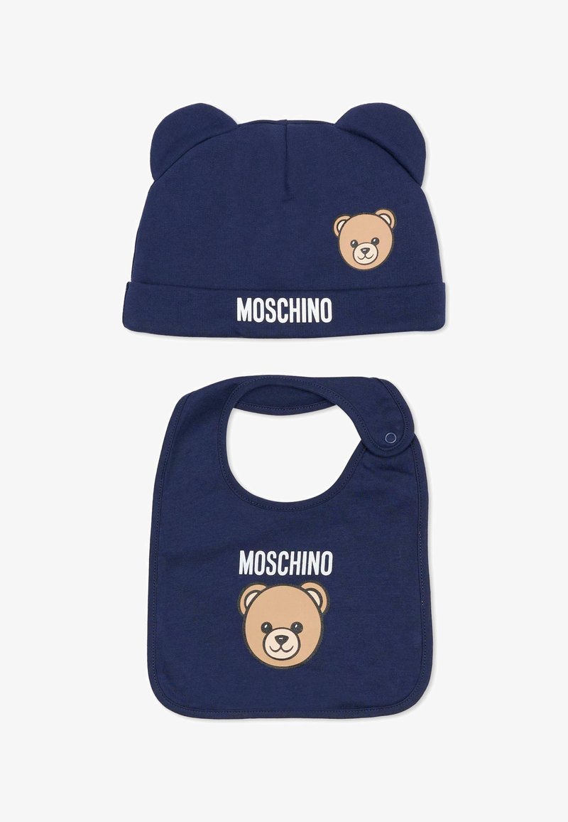 Cappellino da neonato in cotone blu navy con orecchie da orso e volto di orso stampato; bavaglino coordinato con grafica di orso e testo "Moschino" in bianco.