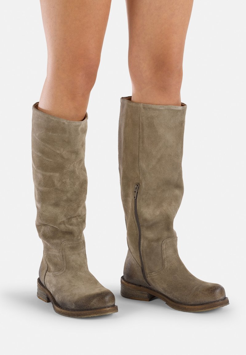 Botas de ante taupe hasta la rodilla, con una textura ligeramente desgastada, punta redondeada y cremallera lateral, que presentan un tacón bajo y apilado.