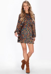 Rochie A-line cu mânecă lungă, având un model paisley multicolor vibrant, cu volan la tiv și o croială lejeră. Purtați-o cu bocanci din suede maroniu.