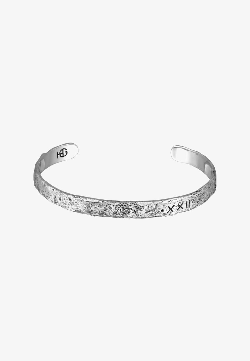 Silver bracelet with a textured, uneven surface, featuring engraved symbols. Open cuff design allows for easy wearing.