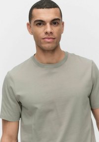 Korte mouwen, ronde hals T-shirt van lichtgroene katoenstof, gladde textuur met minimalistisch ontwerp en geen zichtbare patronen of accenten.