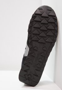 Czarne buty trekkingowe z teksturowaną gumową podeszwą z trójkątnym bieżnikiem, górą z materiału syntetycznego i zamszowego oraz odblaskowymi akcentami.