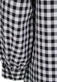 Crna i bijela gingham košulja, sa naboranom puf rukavom, okruglim manžetnama s kopčanjem na dugme, i teksturiranom pamučnom tkaninom.