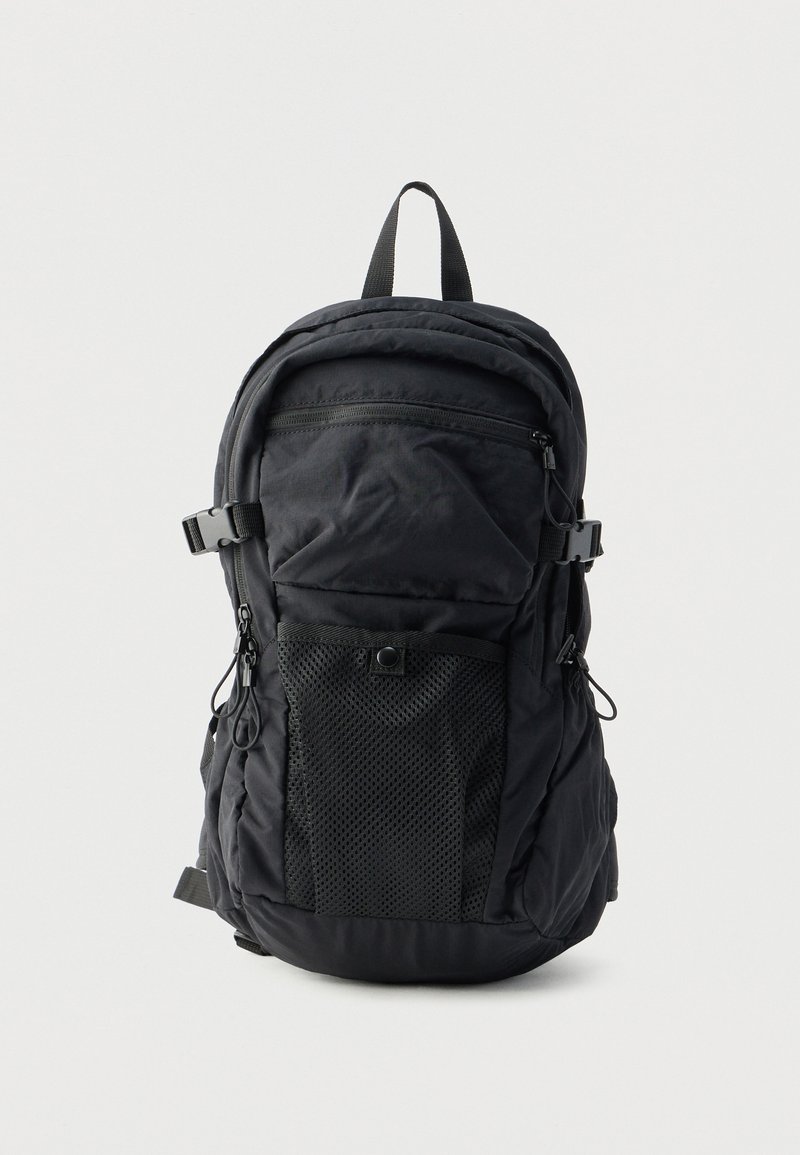 Μαύρο σακίδιο πλάτης με λείο ύφασμα, μπροστινή θήκη από δίχτυ, ρυθμιζόμενους ιμάντες και φερμουάρ, σχεδιασμένο για χρηστικότητα και άνεση.