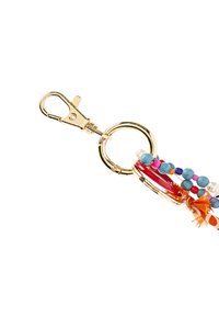 Złoty metalowy klips do breloczka przymocowany do pierścienia z kolorowymi koralikami w odcieniach niebieskiego, czerwonego, różowego i pomarańczowego, z elementem tekstylnym o fakturze.
