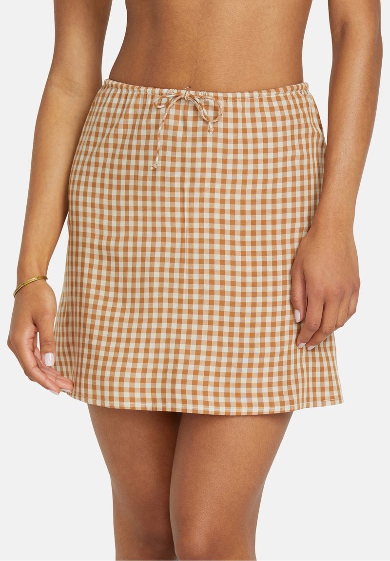 Falda a cuadros en tonos marrón y blanco, con cintura elástica y cordón ajustable, que presenta un corte recto y una textura de tela suave.