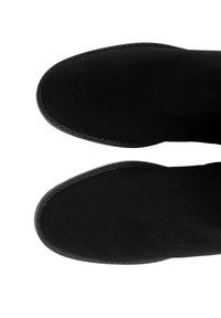 Czarne botki za kostkę o gładkim zamszowym wykończeniu, zaokrąglonym nosku i kontrastującym wykończeniu szwami, ujęte z widoku z góry.