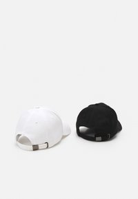 To baseball caps, en hvid og en sort, lavet af stof, har justerbare remme og en bøjet skygge. Enkel design uden yderligere mønstre.