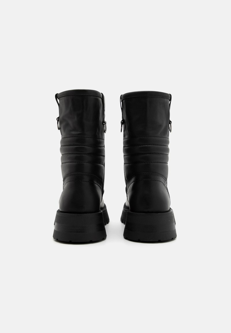 Stivali in pelle nera con finitura texturizzata, dotati di un collo imbottito, anelli per il posizionamento e una suola robusta per una buona trazione.