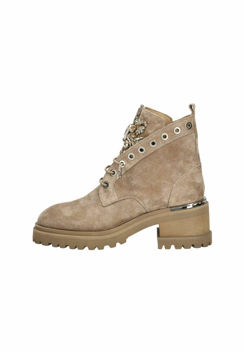 Botín de ante beige hasta el tobillo con un tacón ancho, diseño de cordones, herrajes plateados y un adorno decorativo en el lateral. Superficie texturizada y suela resistente.