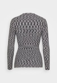 Top aderente a maniche lunghe con un motivo testurizzato in bianco e nero, dotato di scollatura rotonda e orlo leggermente curvato sul retro.