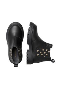 Bottines en cuir noir avec un panneau arrière texturé présentant un motif de cœurs dorés. Semelle en caoutchouc plate avec une languette pour un enfilage facile.