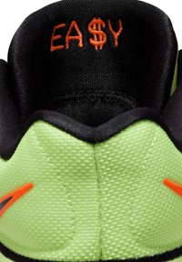 Zapatilla de color verde lima con detalles en negro y un logotipo naranja. La parte superior presenta un material de malla texturizada con un collar acolchado.