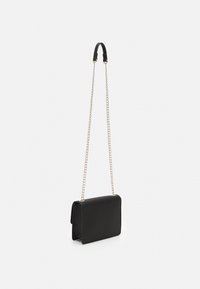 Bolso de cuero sintético negro con forma rectangular, cierre de solapa y correa de cadena dorada. Presenta una textura suave y un diseño minimalista.