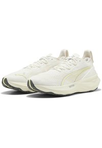 Zapatillas de running ligeras de malla blanca con un patrón texturizado, con un acento amarillo, mediasuela acolchada y suela de goma negra.