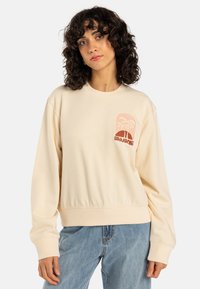 Lichtbeige crewneck sweatshirt met een geribde zoom, met een roze palmboomafbeelding en de tekst "Billabong" op de linker borst.