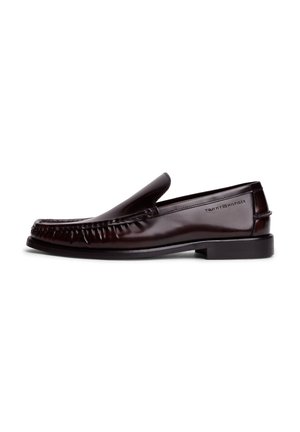 Mocassino slip-on in pelle marrone scuro con dettagli cuciture e tacco basso, logo Tommy Hilfiger in rilievo sul lato.