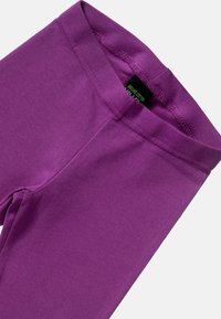 Fioletowe legginsy wykonane z organicznej bawełny, charakteryzujące się gładką fakturą, elastyczną talią oraz prostym wzornictwem bez wzorów czy akcentów.