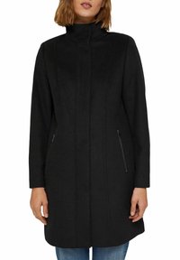 Manteau en mélange de laine noir avec un col haut, des manches longues et deux poches latérales zippées, présentant des détails de couture verticale pour une texture ajoutée.