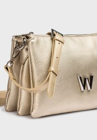 Sac à main en cuir texturé doré avec une bandoulière amovible, présentant un logo "W" argenté proéminent et une finition métallique lisse.